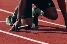 A sprinter kneeling in the starting blocks